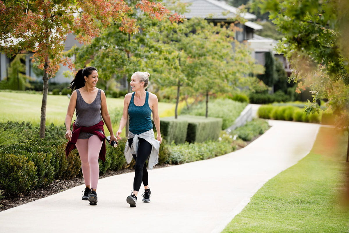 Two woman walking together in masterplanned community path