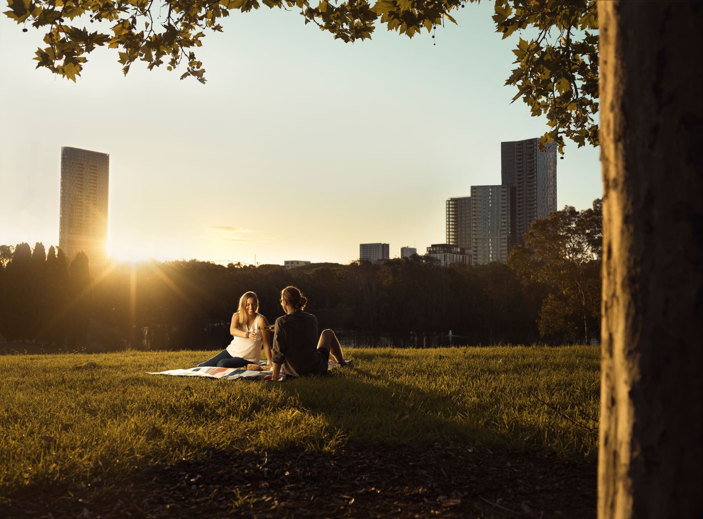 Couple enjoying a picnic in Bicentennial Park at sunset