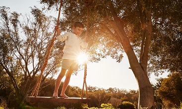 Kid standing on a swing photo