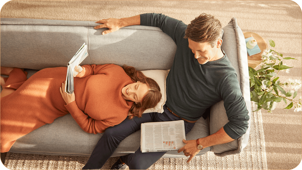 Lifestyle image of couple relaxing on the couch & reading 