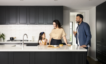 Family standing in kitchen